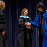 Provost and Faculty shaking President's hand